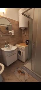 a bathroom with a sink and a washing machine at Apartman Dejanović 2 in Veliko Gradište