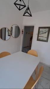 a dining room with a table and two mirrors at Apartman Dejanović 2 in Veliko Gradište +6 photos