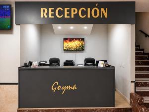 a reception desk in a store with a sign on the wall at Hostal Goyma I in San Fernando de Henares