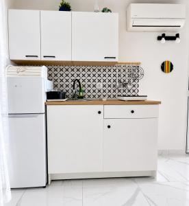 a white kitchen with white cabinets and a counter at Apartmani Điran in Preko +14 photos