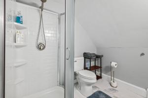 a white bathroom with a toilet and a shower at Cabot Modern Pet Friendly Apt 2nd Floor Studio in Whitefield +15 photos