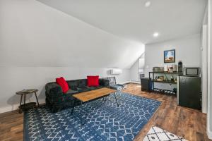 a living room with a black couch and red pillows at Cabot Modern Pet Friendly Apt 2nd Floor Studio in Whitefield