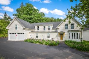 a white house with a garage at Cabot Modern Pet Friendly Apt 2nd Floor Studio in Whitefield
