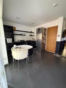a kitchen with a white table and a refrigerator at Mancs&Buborék Kutyabarát Vendégház in Komló +3 photos