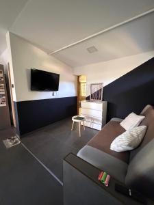 a bedroom with a bed and a tv on a wall at Mancs&Buborék Kutyabarát Vendégház in Komló