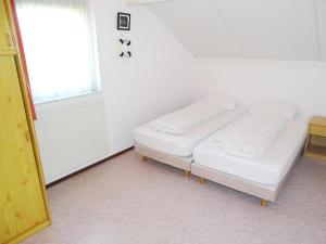 a bedroom with two beds in a room with a window at Bungalow in Breskens near Beach and Lighthouse in Breskens +13 photos