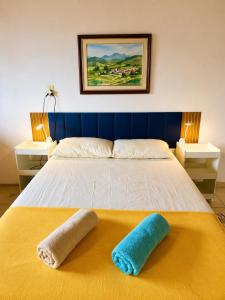 a bedroom with a bed with two towels on it at Reis Family Paraty - Suíte Privativa Nova e Funcional com Varanda in Paraty