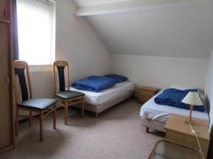 a room with two beds and a chair and a window at Bungalow in Breskens near Beach and Pool in Breskens +17 photos