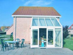 a conservatory with a child standing inside of it at Bungalow in Breskens near Beach and Pool in Breskens