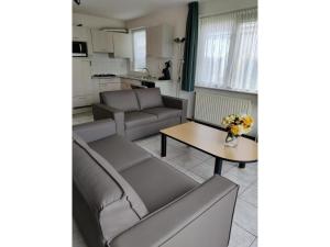 a living room with a couch and a table at Bungalow in Breskens near Beach and Pool in Breskens