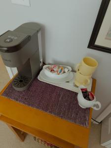 a table with a coffee maker and a plate and aucer at Lawrence Loft in Lawrence