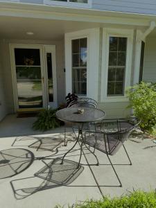a patio with a table and chairs in front of a house at Lawrence Loft in Lawrence