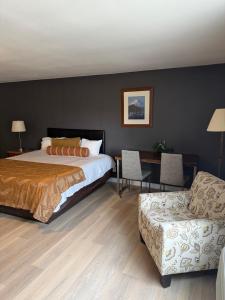 a bedroom with a bed and a couch and a chair at Naval Suites by FairBridge in Bremerton
