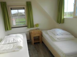 two beds in a small room with a window at Holiday Home Breskens near the Coast in Breskens +29 photos