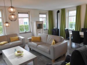 a living room with a couch and a table at Holiday Home Breskens near the Coast in Breskens
