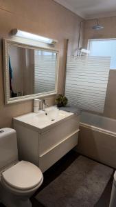 a bathroom with a sink and a toilet and a tub at Keflavik Heart in Keflavík +5 photos