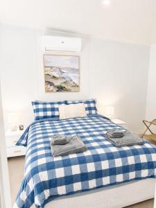 a blue and white bed with two towels on it at Gem on Matrix - Hidden Retreat with Deck in Lightning Ridge