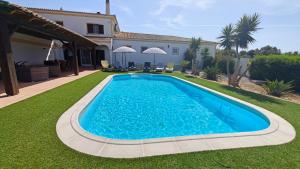 a swimming pool in the yard of a house at Quinta das Lameiras in Lagoa