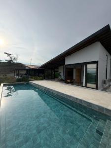 a swimming pool in front of a house at CASALIA Sopetran in Sopetrán
