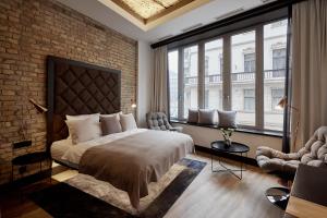 - une chambre avec un grand lit et un mur en briques dans l'établissement The Loft Budapest, à Budapest