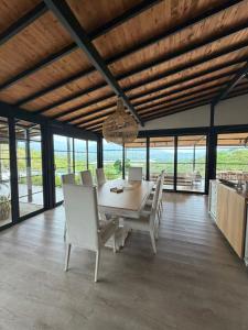 a dining room with a table and chairs and windows at CASALIA Sopetran in Sopetrán