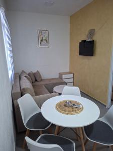a living room with a white table and chairs at Apartmani Ksenija Sofija in Igalo
