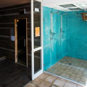 a bathroom with a shower with blue tiled walls at T8 Sunset Tihany 19 in Tihany +13 photos