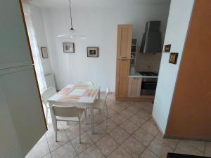 a white table and chairs in a room with a kitchen at The sisters apartment in Punta Marina