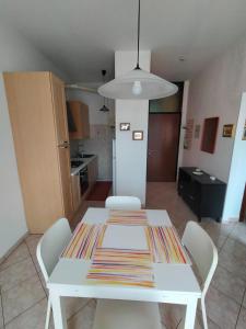 a white table and chairs in a kitchen at The sisters apartment in Punta Marina