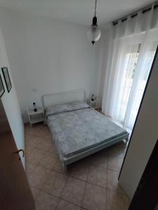 a bedroom with a bed in a white room at The sisters apartment in Punta Marina +2 photos