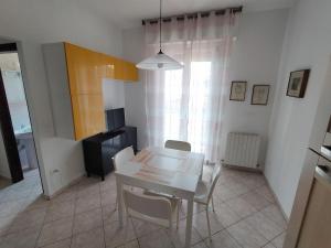 a dining room with a white table and chairs at The sisters apartment in Punta Marina