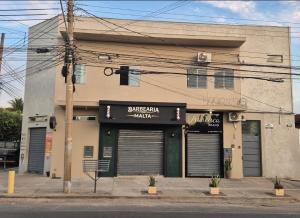 a building with two garage doors on a street at AP Completo Próx Centro, Hospitais, Dist Industrial in Montes Claros