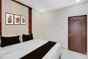 a bedroom with a large bed and a wooden door at Hotel O RB Delight in Karīmnagar