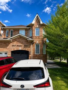 a white car parked in front of a house at The Quiet Nest in Mississauga