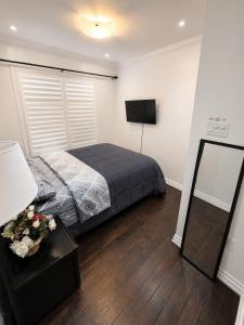a bedroom with a bed and a television in it at The Quiet Nest in Mississauga