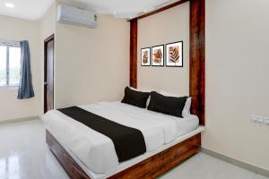 a bedroom with a bed with a wooden headboard at Hotel O RB Delight in Karīmnagar