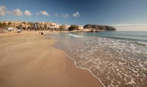 a beach with a group of people and the ocean at La Sort Boutique Hotel in Moraira