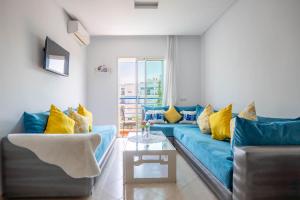 a living room with a blue couch and yellow pillows at Brisa Marina Cabo in Cabo Negro