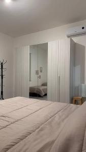 a bedroom with a large bed and a mirror at Bilocale a 300m dal mare e 100m fermata filobus in Pescara