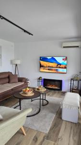 a living room with a couch and a fireplace at Nebeska Terasa in Knić