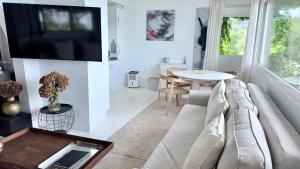a living room with a couch and a tv on a wall at Cabanas da Auga A in A Telleira