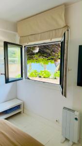 a room with two windows and a bed in it at Cabanas da Auga A in A Telleira +16 photos