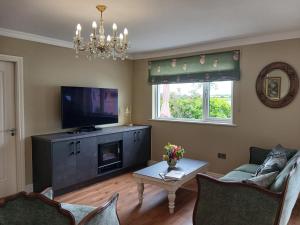 a living room with a tv and a couch and a table at Sheiling Accommodation in Castlemartyr