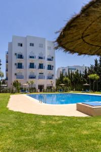 a swimming pool in front of a large building at Brisa Marina Cabo in Cabo Negro