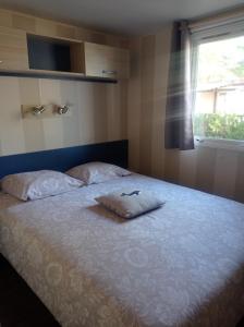 a bed with a pillow on it in a bedroom at Mobil home YANN in Sainte-Croix-de-Verdon