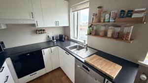 a kitchen with white cabinets and a sink and a window at Keflavik Heart in Keflavík