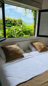 a bed in a room with a large window at Cabanas da Auga B in Casas Novas
