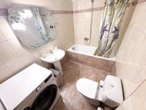 a bathroom with a toilet sink and a washing machine at Alexandros House in Néa Tríglia +8 photos