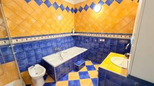 a blue tiled bathroom with a tub and a toilet at Hiša Elsbacher Laško in Laško +16 photos