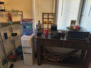 a kitchen with a table with a microwave and a refrigerator at Briugu's Bunkhouse in Denver +1 photo